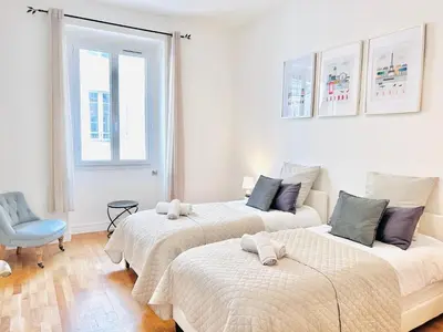 a bedroom with two beds and a blue chair at 2 Bedroom flat Cannes Center La Croisette Banane in Cannes