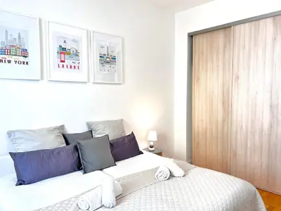 a bedroom with a large white bed with blue pillows at 2 Bedroom flat Cannes Center La Croisette Banane in Cannes