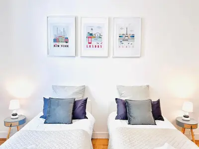 two beds in a room with three pictures on the wall at 2 Bedroom flat Cannes Center La Croisette Banane in Cannes