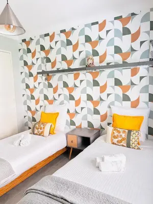 two beds in a room with a patterned wall at 2 bedroom luxury flat with Balcony Cannes Center in Cannes