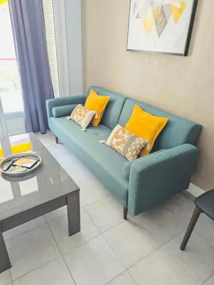 a living room with a blue couch with yellow pillows at 2 bedroom luxury flat with Balcony Cannes Center in Cannes