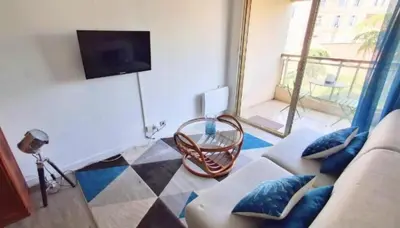 a living room with a couch and a tv at L'ILOT avec balcon, mignon et charmant, un havre de paix au cœur du centre-ville in Cannes