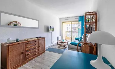a living room with a dresser and a couch at L'ILOT avec balcon, mignon et charmant, un havre de paix au cœur du centre-ville in Cannes