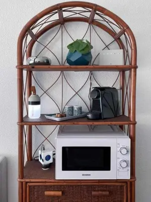 a microwave on a wooden shelf with a microwave oven at L'ILOT avec balcon, mignon et charmant, un havre de paix au cœur du centre-ville in Cannes
