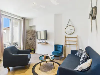 a living room with a blue couch and two chairs at LE SPECTACULAIRE moderne et raffiné, idéalement situé à deux pas du Palais et plages in Cannes