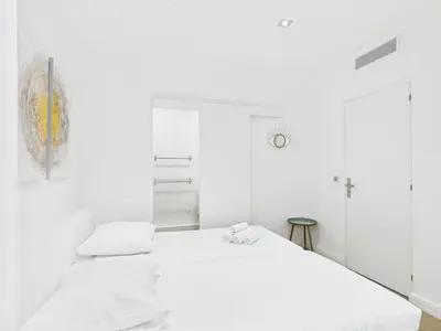 a white bedroom with two beds in it at LE SPECTACULAIRE moderne et raffiné, idéalement situé à deux pas du Palais et plages in Cannes