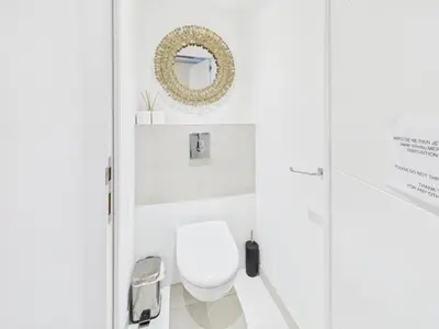 a white bathroom with a toilet and a mirror at LE SPECTACULAIRE moderne et raffiné, idéalement situé à deux pas du Palais et plages in Cannes