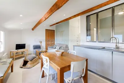 a kitchen and living room with a wooden table and chairs at Bronze in Cannes