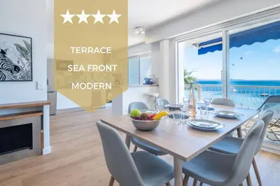 a dining room with a table and chairs with a ocean view at RARE! 2-Br Seafront Apartment in Cannes