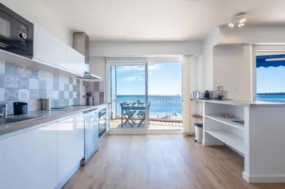 a kitchen with white cabinets and a view of the ocean at RARE! 2-Br Seafront Apartment in Cannes