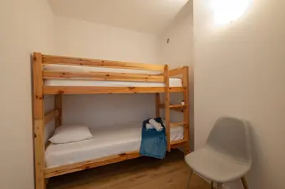 a small room with two bunk beds and a chair at RARE! 2-Br Seafront Apartment in Cannes