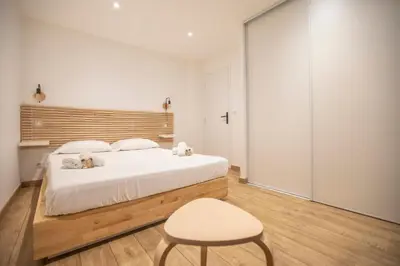 a bedroom with a large white bed and a chair at Montgolfiere Apartment by Connexion in Cannes