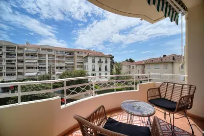 a balcony with two chairs and a table on a balcony at IMMOGROOM - Spacious 3-room apartment - Garage - Terrace - Air conditioning in Cannes