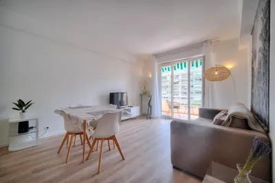 a living room with a table and chairs and a couch at IMMOGROOM - Spacious 3-room apartment - Garage - Terrace - Air conditioning in Cannes