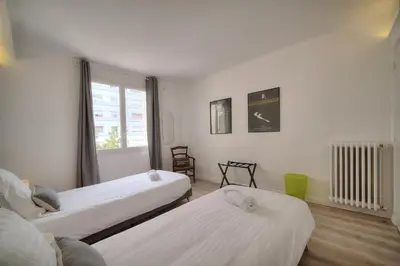a bedroom with two beds and a window at IMMOGROOM - Spacious 3-room apartment - Garage - Terrace - Air conditioning in Cannes