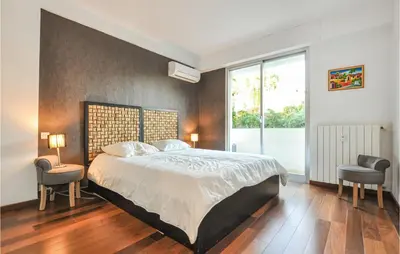 a bedroom with a large bed and two chairs at 1 Bedroom Gorgeous Apartment In Cannes in Cannes