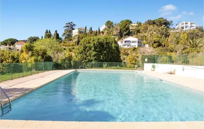 a swimming pool with blue water in a yard at 1 Bedroom Gorgeous Apartment In Cannes in Cannes