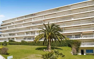 a palm tree in front of a large building at 1 Bedroom Gorgeous Apartment In Cannes in Cannes