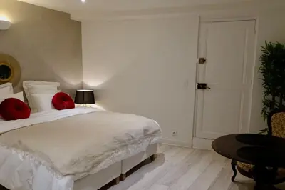 a bedroom with a large white bed with red pillows at Studio Suquet 1 in Cannes