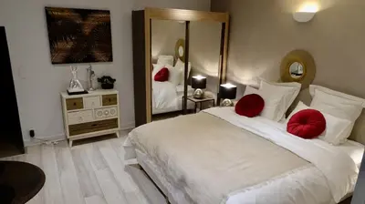a bedroom with a large white bed with red pillows at Studio Suquet 1 in Cannes
