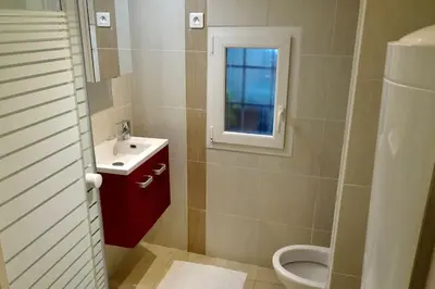 a bathroom with a toilet and a sink and a window at Studio Suquet 1 in Cannes