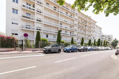 a row of cars parked in front of a large building at Hayda - Proche plage et congrès in Cannes