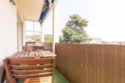 a patio with two wooden chairs and a wooden fence at Hayda - Proche plage et congrès in Cannes