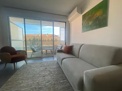 a living room with a couch and a large window at Cannes, appartement avec parking+terrasse, Croisette à pied! in Cannes