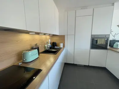 a kitchen with white cabinets and a toaster on a counter at Cannes, appartement avec parking+terrasse, Croisette à pied! in Cannes