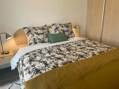 a bedroom with a large bed with a green pillow at Cannes, appartement avec parking+terrasse, Croisette à pied! in Cannes