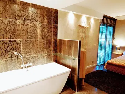a bathroom with a bath tub and a bedroom at SUNRISE & SUNSET PALM BEACH CROISETTE in Cannes