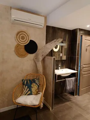 a bathroom with a wicker chair and a sink at SUNRISE & SUNSET PALM BEACH CROISETTE in Cannes