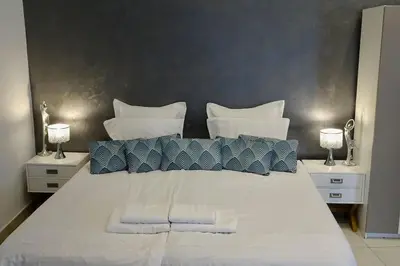 a large white bed with blue and white pillows at Studio Suquet 3 in Cannes