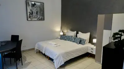 a bedroom with a bed and a table with a desk at Studio Suquet 3 in Cannes