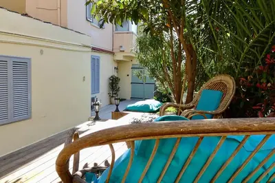 a wooden bench sitting on a porch with a tree at Studio Suquet 3 in Cannes