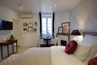 a bedroom with a bed and a table with chairs at Studio Suquet 2 in Cannes