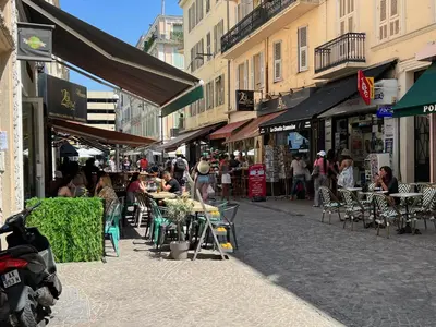 a group of people sitting at tables on a street at Newly Renovated Luxury Suite in the Center of Cannes in Cannes