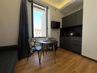 a living room with a table and chairs and a kitchen at Newly Renovated Luxury Suite in the Center of Cannes in Cannes