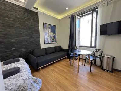 a living room with a couch and a table at Newly Renovated Luxury Suite in the Center of Cannes in Cannes