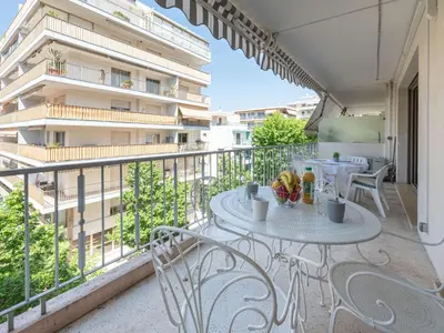 a balcony with a table and chairs and a building at Apartment Le Valencia by Interhome in Cannes