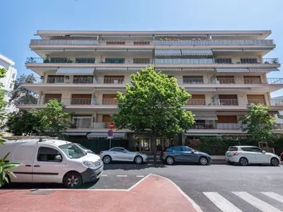 a large building with cars parked in a parking lot at Apartment Le Valencia by Interhome in Cannes