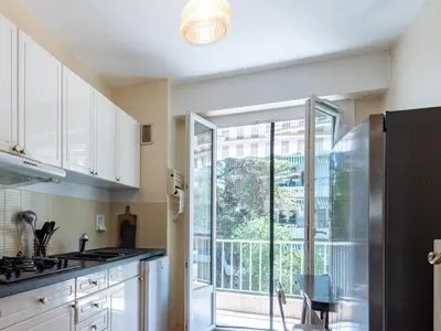 a kitchen with white cabinets and a large window at Apartment Le Valencia by Interhome in Cannes
