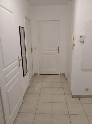 a hallway with a white door and a tile floor at Sainte Rosalie in Cannes