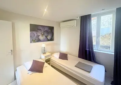 two beds in a room with a window at Viva Riviera Central 1 Bedroom Place Gambetta in Cannes