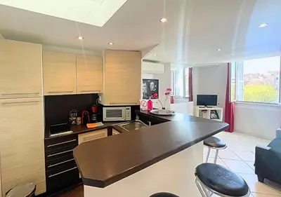 a kitchen with wooden cabinets and a counter top at Viva Riviera Central 1 Bedroom Place Gambetta in Cannes