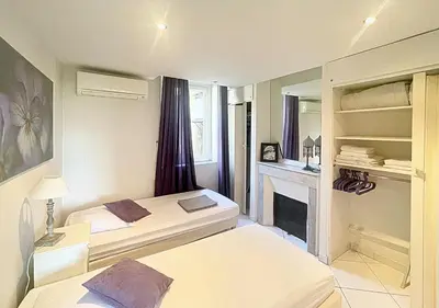 a bedroom with two beds and a fireplace at Viva Riviera Central 1 Bedroom Place Gambetta in Cannes