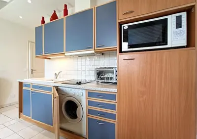 a kitchen with a washing machine and a microwave at Viva Riviera Central 1 Bedroom Place Gambetta in Cannes