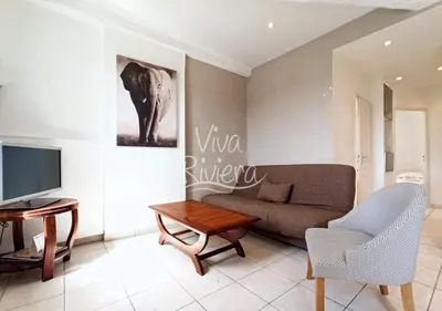 a living room with a couch and a table at Viva Riviera Central 1 Bedroom Place Gambetta in Cannes