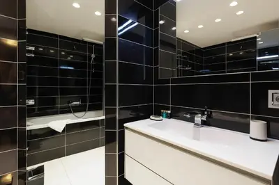 a bathroom with a sink and black tiled walls at 7 Croisette 7C201 in Cannes