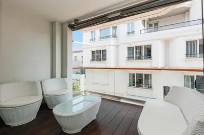 a balcony with wicker chairs and a large window at 7 Croisette 7C201 in Cannes